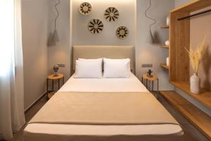 Costa D' Ifesto في Agios Ioannis Kaspaka: غرفة نوم بسرير كبير مع طاولتين جانبيتين