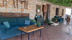 uma sala de estar com um sofá azul e uma mesa de madeira em Cibanto de las Maravillas em Riópar