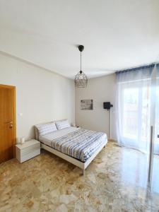 a bedroom with a bed and a large window at Affittacamere Zona Caserma-Stazione in Foligno
