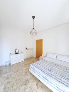 a white bedroom with a large bed and a table at Affittacamere Zona Caserma-Stazione in Foligno
