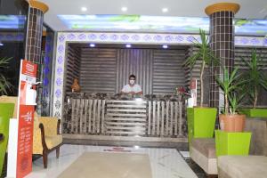 a man wearing a mask standing behind a bar at Selinus Beach Club Hotel in Gazipasa +269 photos