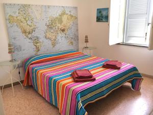 a bedroom with a colorful bed with a map on the wall at Villa Mira Capri in Procida