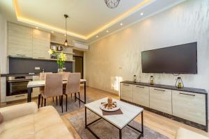 a living room with a table and a tv at Luxury Apartments Queen in Petrovac na Moru