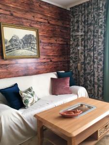 a living room with a white couch and a wooden wall at Ferienwohnung Storchenblick in Zurow