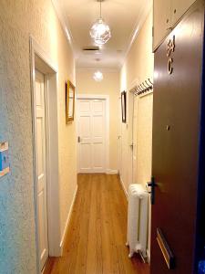 a hallway with a white door and a hallway with a hard wood floor at Old Spittal Hospital Apartment in Stirling +49 photos