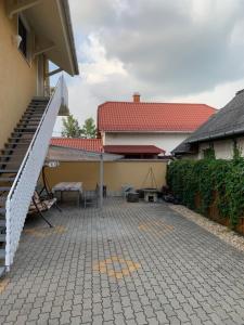 eine Terrasse mit einer Bank und einem Gebäude in der Unterkunft Gázláng Apartman in Hajdúszoboszló