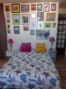a bedroom with a bed and a wall of pictures at Chez Coco, 7 persons, triangle d'or in Deauville