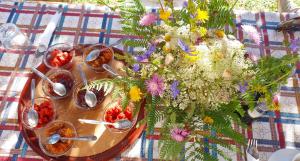 una mesa con un jarrón de flores y cucharas en Guest house PANORAMA, en Theth