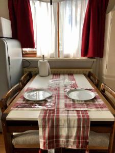 a table with a plaid table cloth and plates on it at Retro Relax Resort midden in het bos op de Veluwe in Putten in Putten