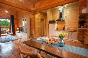 a kitchen with a table in a wooden cabin at Country Lodge Vuković in Rakovica