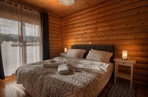 1 dormitorio con 1 cama con pared de madera en Country Lodge Vuković en Rakovica