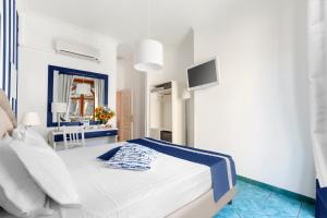 1 dormitorio blanco con 1 cama y TV en Hotel Herculaneum, en Ercolano