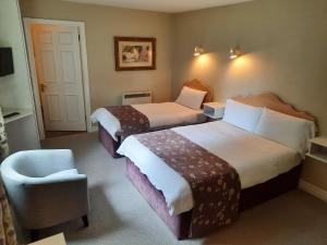 a hotel room with two beds and a chair at Sea Dew B&B in Tullamore