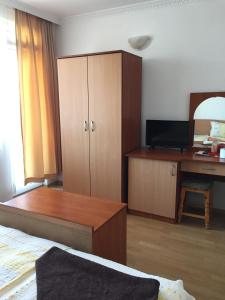 a living room with a bed and a desk at Къща за гости Aтанасов II in Primorsko