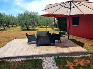 a patio with a table and chairs and an umbrella at Artemida in Medulin