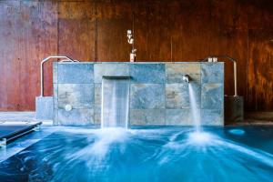 a large pool of water with a fountain at Hotel Spa Aguas de los Mallos in Murillo de Gállego