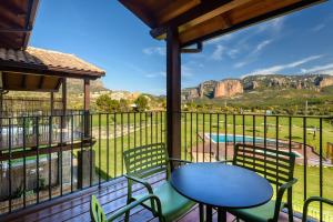 a patio with a table and chairs and a view of a pool at Hotel Spa Aguas de los Mallos in Murillo de Gállego