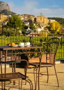 a table and chairs with a view of a city at Hotel Spa Aguas de los Mallos in Murillo de Gállego