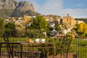 a table and chairs with a view of a city at Hotel Spa Aguas de los Mallos in Murillo de Gállego