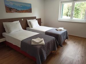 Una habitación de hotel con dos camas y dos ventanas. en Villa Novak, en Rab