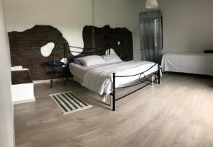 1 dormitorio con 1 cama y suelo de madera en La Torretta, en Orte