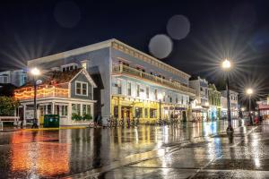 a wet city street at night with buildings at Murray Hotel in Mackinac Island