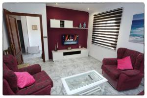 a living room with two couches and a table at Cova Do Raposo in Lagarteira