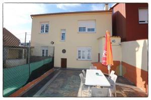 a patio with a white table and an umbrella at Cova Do Raposo in Lagarteira