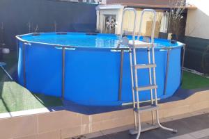 a ladder next to a swimming pool with a blue tank at Cova Do Raposo in Lagarteira