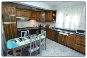 a kitchen with wooden cabinets and a table and chairs at Cova Do Raposo in Lagarteira
