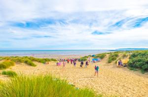 a group of people standing on a beach at Sea 'n' Stars Platinum Plus Holiday home with Views, Free Wifi and Netflix in Camber