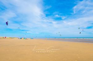 a group of people flying kites on the beach at Sea 'n' Stars Platinum Plus Holiday home with Views, Free Wifi and Netflix in Camber