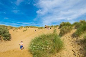 a boy walking down a sand dune on a beach at Sea 'n' Stars Platinum Plus Holiday home with Views, Free Wifi and Netflix in Camber