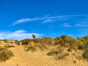 a person standing on top of a sand hill at Sea 'n' Stars Platinum Plus Holiday home with Views, Free Wifi and Netflix in Camber