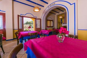 un restaurante con mesas y sillas rosas y azules en Hotel Rural El Molino de Felipe, en Mula