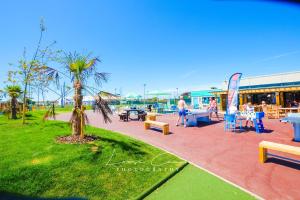 a park with tables and chairs and people on the beach at Sea 'n' Stars Platinum Plus Holiday home with Views, Free Wifi and Netflix in Camber