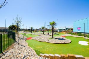 a golf course with palm trees and a putting green at Sea 'n' Stars Platinum Plus Holiday home with Views, Free Wifi and Netflix in Camber