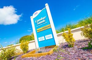 a sign in front of a building with a blue sky at Sea 'n' Stars Platinum Plus Holiday home with Views, Free Wifi and Netflix in Camber