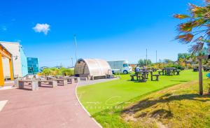 a picnic area with picnic tables and a building at Sea 'n' Stars Platinum Plus Holiday home with Views, Free Wifi and Netflix in Camber