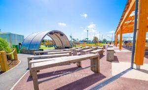 a row of benches in front of a playground at Sea 'n' Stars Platinum Plus Holiday home with Views, Free Wifi and Netflix in Camber