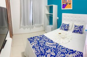 ein Schlafzimmer mit einem Bett mit blau-weißer Bettwäsche in der Unterkunft Pousada Vovó Zilda Maragogi in Maragogi + 78 Fotos