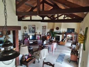 a large living room with wooden ceilings and a room with tables at Casa Vista Para o Mar in Ilhabela