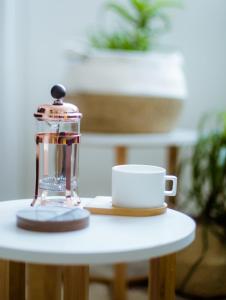 eine Kaffeemaschine und eine Tasse auf dem Tisch in der Unterkunft Tuynhuys Stylish, Modern, Walk to Restaurants and CBD in Kapstadt