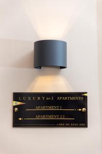 a light hanging on a wall with a sign at Luxury Number 1 Apartments in Rijeka