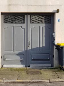 une grande porte de garage bleue sur un bâtiment dans l'établissement GITE DE L'OCTROI -Proche Centre REMIREMONT, à Remiremont