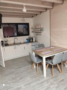 eine Küche und ein Esszimmer mit einem Holztisch und Stühlen in der Unterkunft Domki letniskowe Marcinowa Wola in Miłki