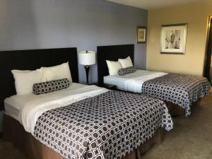 2 camas en una habitación de hotel con faldas en Motel 75 Monroe, en Monroe