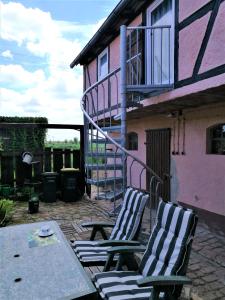 twee stoelen en een tafel voor een huis bij Familienfreundliches Ferienhaus mit 3 Schlafzimmern in Oldisleben