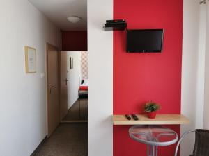 a red wall in a room with a table and a chair at Leśna Villa in Wiśniówka Mała