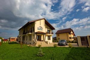 un bâtiment avec une voiture garée devant lui dans l'établissement Pensiunea Mateo, à Buzău